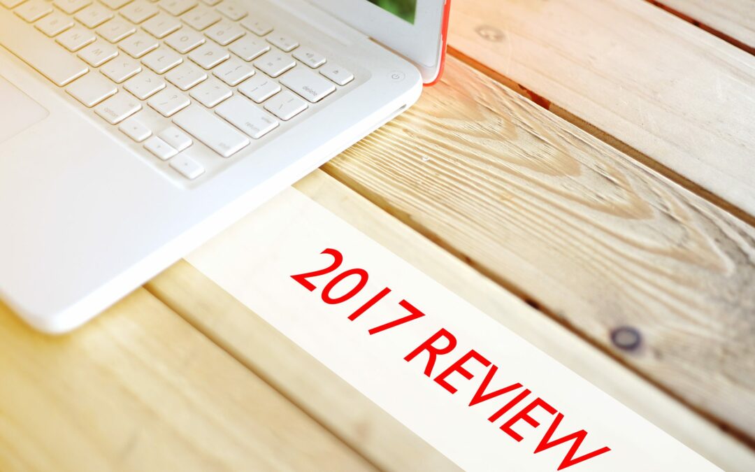 laptop on wood table next to 2017 review lettering